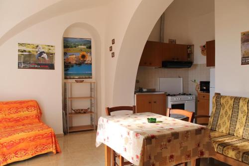 ein Wohnzimmer mit einem Tisch und einer Küche in der Unterkunft Agriturismo Podere Montenero in Alberese