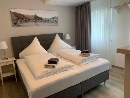 a bedroom with a bed with two towels on it at Stumbergers Hotel in Cochem