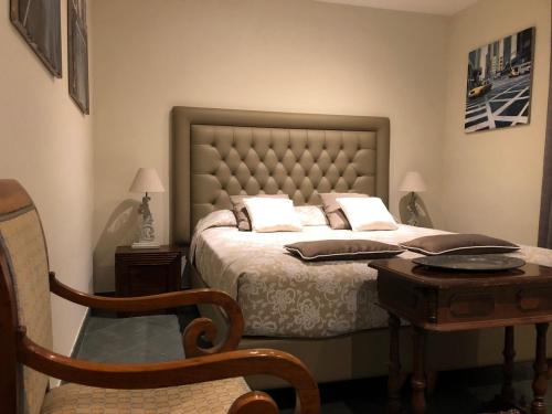 a bedroom with a bed and a table and a chair at Villa Abbamer in Grottaferrata