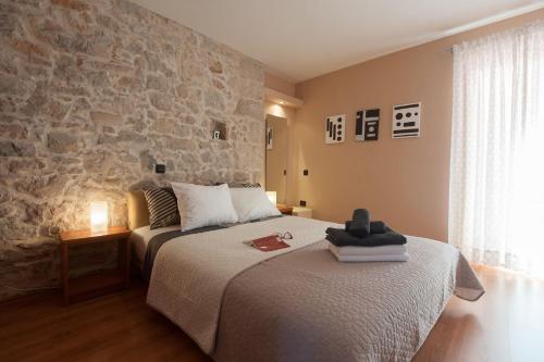um quarto com 2 camas e uma parede de pedra em Apartments Ivan - great location em Poljana