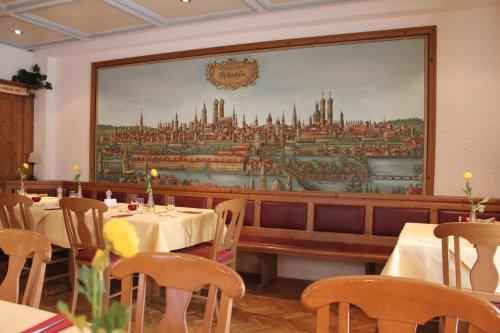 a dining room with tables and a large painting on the wall at Hotel Schiller in Olching