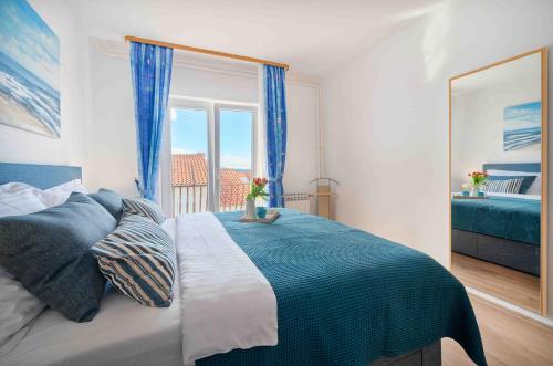 um quarto com uma cama grande e uma janela em Apartments Valentino em Vodice