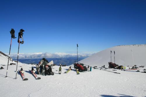 a group of people sitting on a snow covered mountain at Rifugio Il Ginepro dell'Etna in Linguaglossa