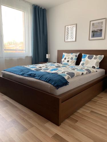 een slaapkamer met een groot bed met blauwe lakens bij H Central Apartment in Hévíz