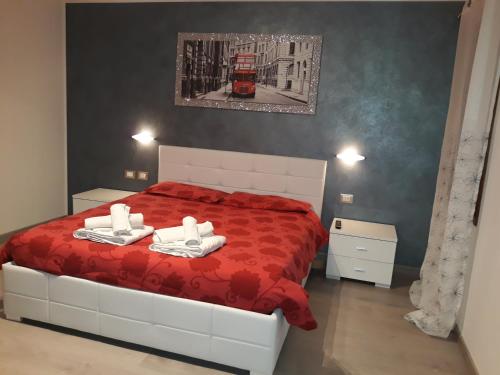 a bedroom with a red bed with two towels on it at B&B Casa Taty in Dolo
