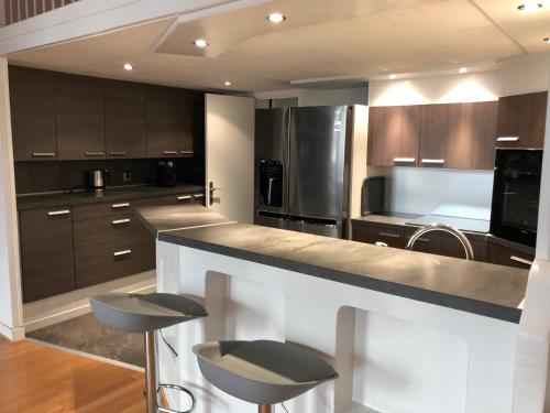 une cuisine avec des armoires en bois et un comptoir avec des tabourets dans l'établissement Vieux port de Cannes, à Cannes