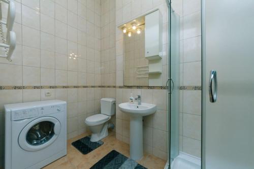 a bathroom with a toilet sink and a washing machine at Apartment on Saksahanskoho Street in Kyiv