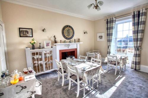 a dining room with a table and chairs and a fireplace at Craigmount in Wigtown