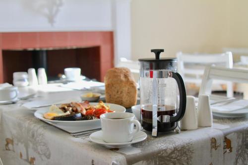 a table with a coffee pot and a plate of food at Craigmount in Wigtown