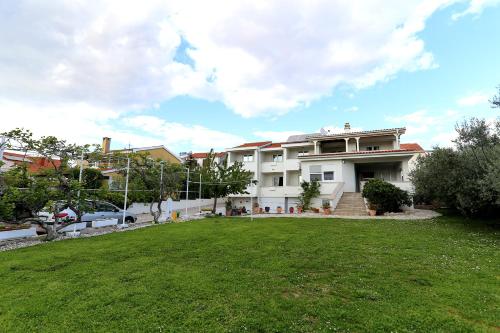 ein großes weißes Haus mit Rasen davor in der Unterkunft Villa Mičić in Zadar