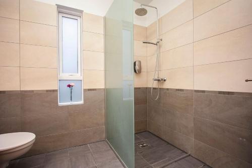 a bathroom with a shower with a toilet and a window at Cozy 3 bedroom house near the Blue lagoon in Njarðvík