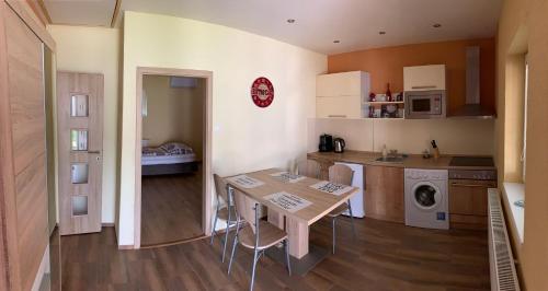 a kitchen with a wooden table and a kitchen with a sink at Apartmány Dimitra in Štúrovo