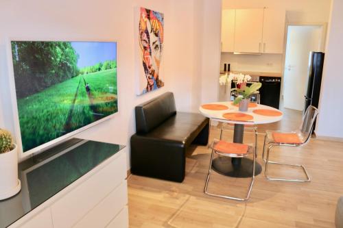 a living room with a television and a table and chairs at Ferienwohnung Seestern in Steinhude, ruhig gelegen , 2 Schlafzimmer, 2 Bäder, Freies WLAN in Wunstorf