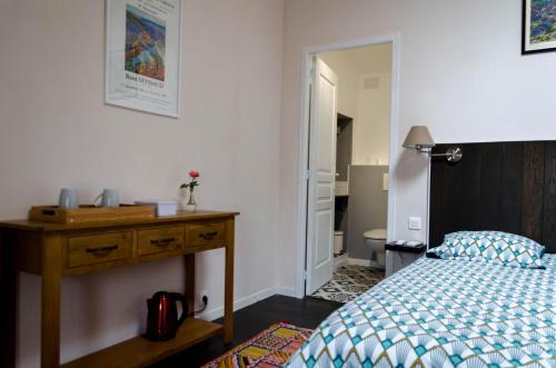 a bedroom with a bed and a wooden dresser and a desk at Gite DURANCE in Mallemort