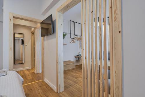 a hallway leading to a bedroom with a bed and a television at A.P. Acropolis View Apartments in Athens
