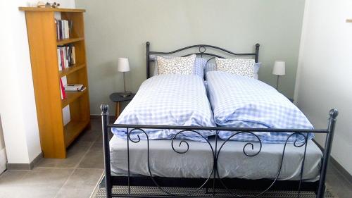Schlafzimmer mit einem Bett mit blauen und weißen Kissen in der Unterkunft Rebgärtle in Britzingen