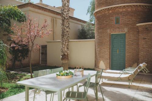 a patio with a table and chairs in front of a building at Les Deux Tours in Marrakech