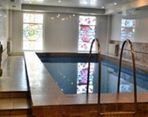 a swimming pool in a building with stained glass windows at Bumerang Hotel in Lviv