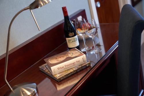 a bottle of wine sitting on a table with wine glasses at Best Western Plus The Connaught Hotel and Spa in Bournemouth
