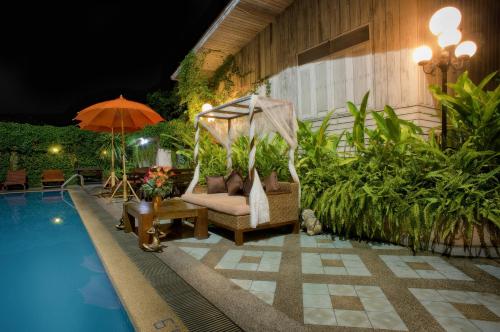 a hammock next to a swimming pool at night at Chiangmai Gate Hotel in Chiang Mai