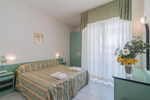 a hotel room with a bed and a window at Residence Baltic in Cattolica