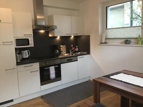 a kitchen with white appliances and a wooden table at Ferienwohnung Marie in Oetz