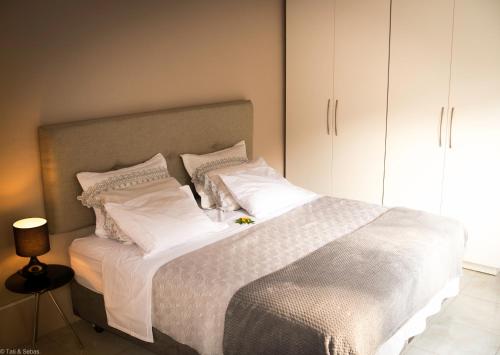 a bedroom with a bed with white sheets and pillows at Suíte privada no meio da natureza serrana. in Teresópolis