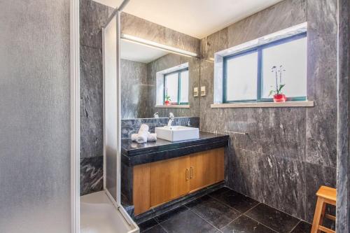 ein Badezimmer mit Waschbecken und Dusche in der Unterkunft Villa do Cisne in Charneca