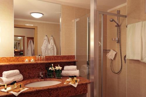 a bathroom with a sink and a shower at Ganischgerhof Mountain Resort & Spa in Nova Ponente