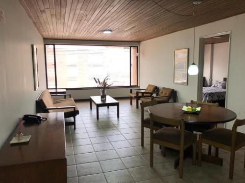 een woonkamer met een tafel en stoelen bij Apartamentos Percales in Bogota