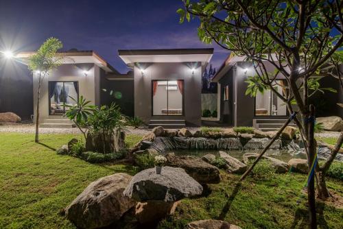 a home with a pond in the yard at night at Hua Hin Lae I Aoon in Hua Hin