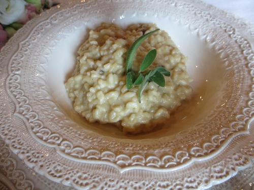 a plate of risotto with a green garnishment on it at Agriturismo Il Felciaione in Massa Marittima