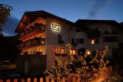 a large white building with lights on it at night at Apart Hotel Garni Kofler in Fiss
