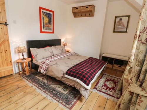 a bedroom with a bed with a plaid blanket at Crinan Canal Cottage No8 in Lochgilphead