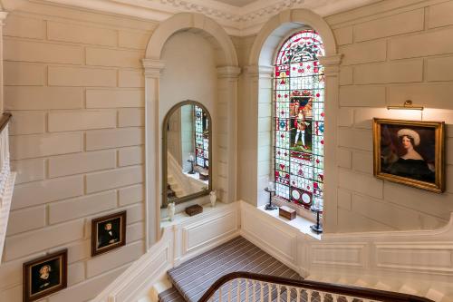 una escalera en un edificio con una vidriera en Eshott Hall en Morpeth