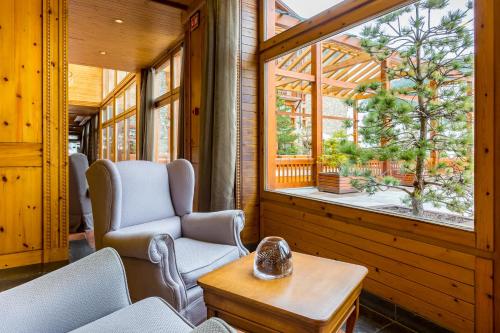 a room with chairs and a table and a window at Sport Hotel Village in Soldeu