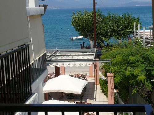 a balcony with a table and chairs and the ocean at Violetta in Kamena Vourla