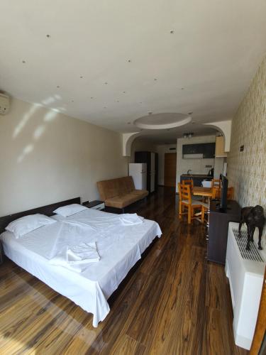 1 dormitorio con cama, mesa y cocina en Apartments in Princess Residence en Balchik