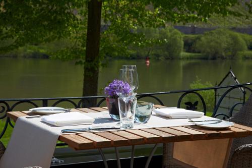 a wooden table with a white table cloth and glasses on it at Hotel Reiler Hof in Reil