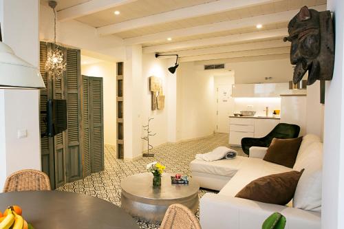 a living room with a white couch and a table at Graffiti Suites Málaga in Málaga