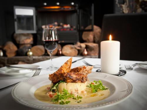 a plate of food on a table with a candle at Llechwen Hall in Pontypridd