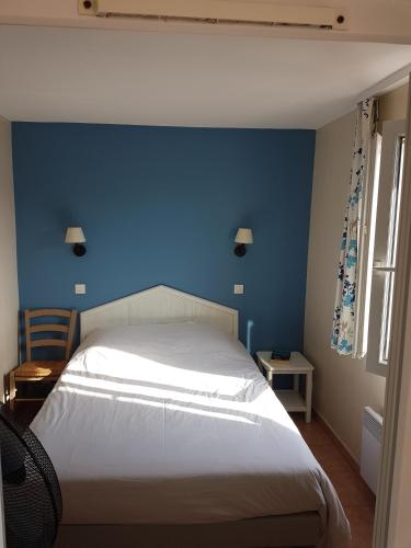 une chambre avec un mur bleu et un lit dans l'établissement Résidence les rivages de la coudouliere, à Six-Fours-les-Plages