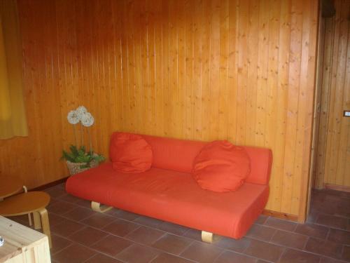 a red couch with two pillows sitting in a room at Agriturismo San Cataldo in Motta Camastra