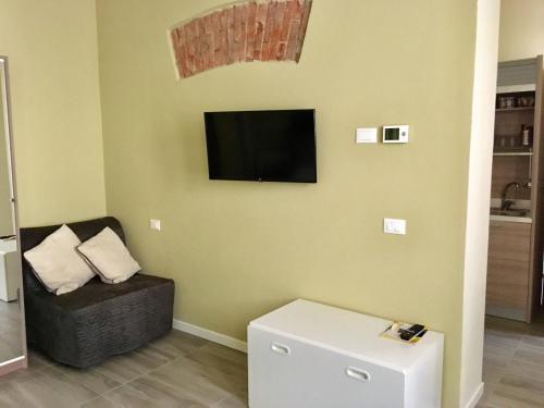 ein Wohnzimmer mit einem Stuhl und einem Flachbild-TV in der Unterkunft MONOLOCALE VICINO MILANO1 in Lodi