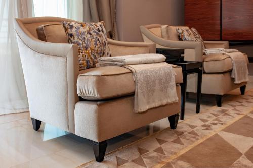 a living room with two chairs and a table at Alàbriga Hotel GL in S'Agaro