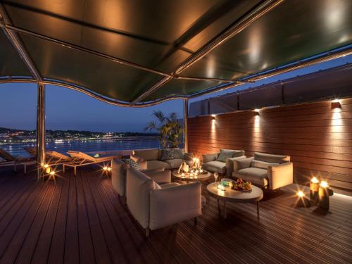 a deck with couches and tables on a boat at Alàbriga Hotel GL in S'Agaro
