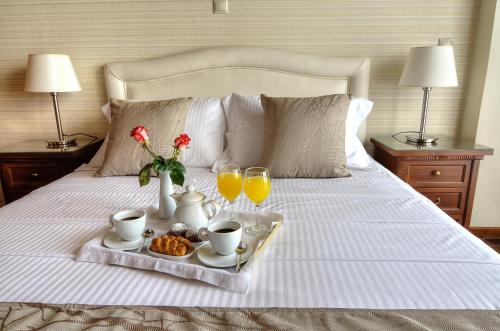 a tray of breakfast foods on a bed with two lamps at Paradise House in Liapades