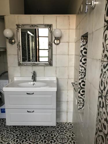 une salle de bain avec un lavabo blanc et un miroir dans l'établissement APPARTEMENT BASTIA AU PIED DU VIEUX PORT, à Bastia