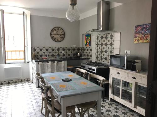 une cuisine avec une table, des chaises et une horloge murale dans l'établissement APPARTEMENT BASTIA AU PIED DU VIEUX PORT, à Bastia