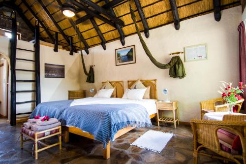 a bedroom with a bed and a table and chairs at Etusis Lodge in Usakos